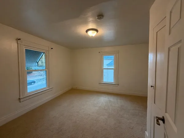 an empty room with windows and closet