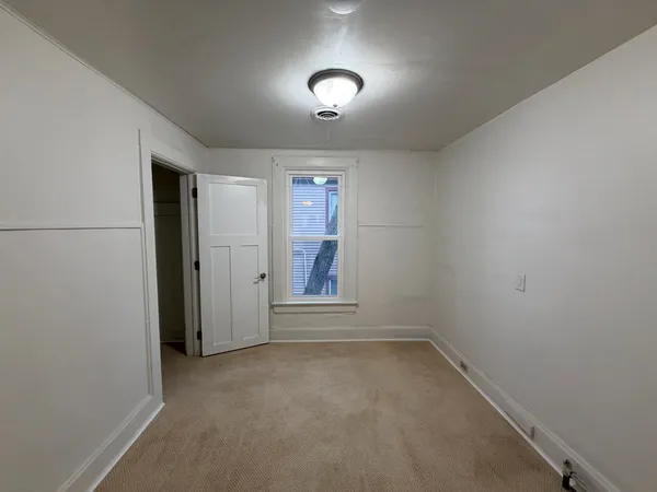 an empty room with closet and windows