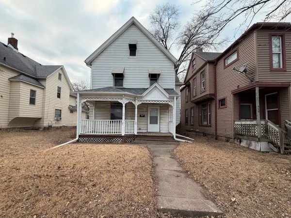 a front view of a house with a yard and parking space