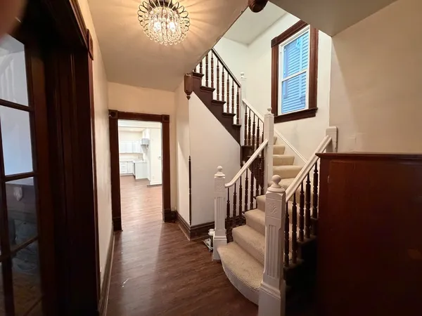 a view of entryway and hall with wooden floor