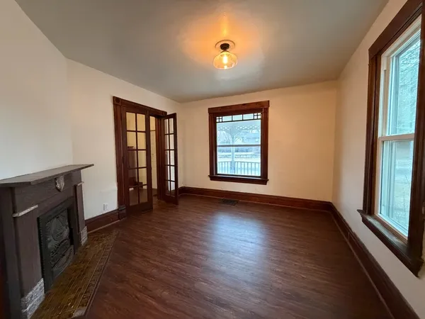 an empty room with wooden floor and windows