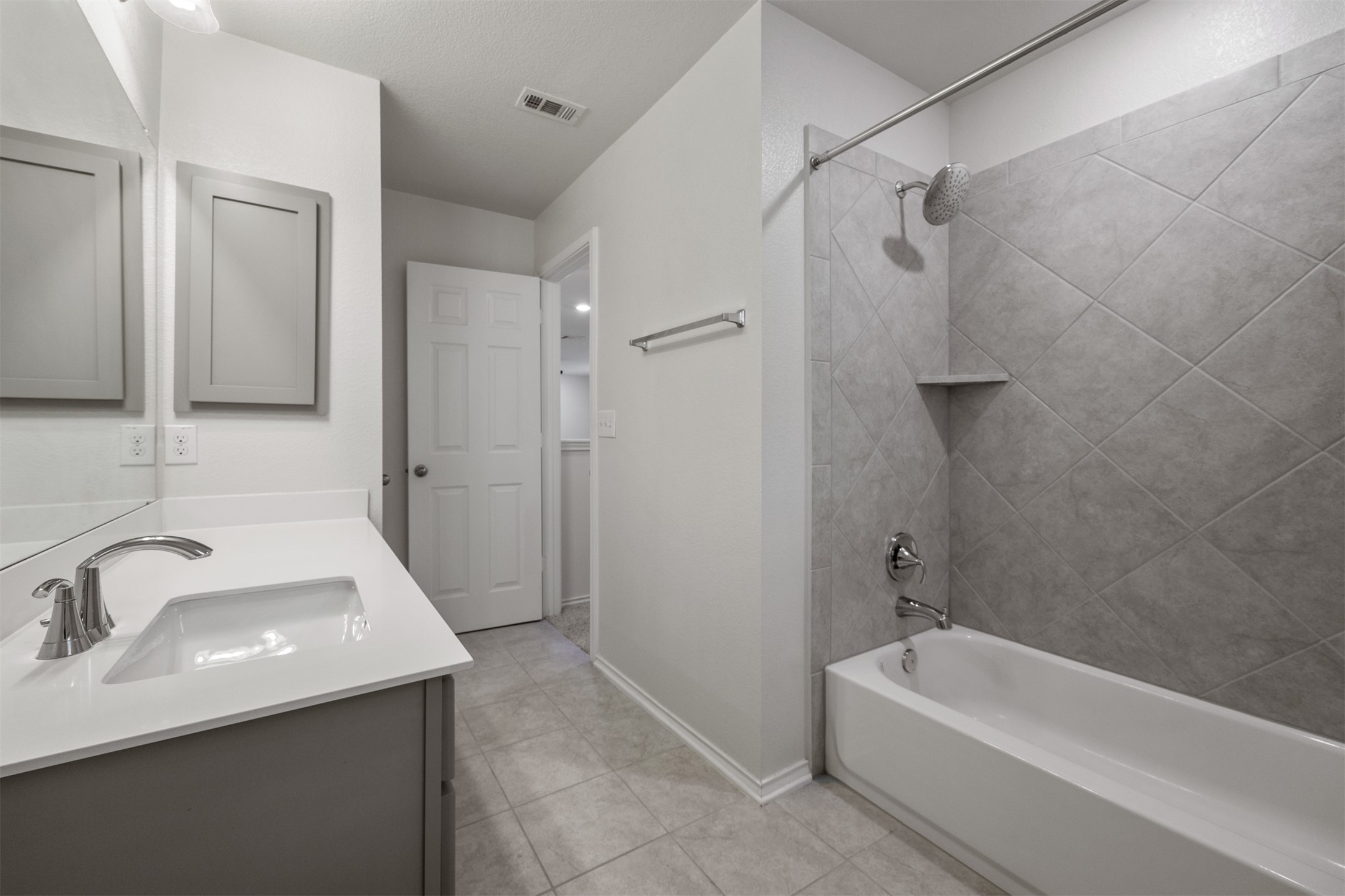7009 Nutria Run Austin, TX 78744 - Photo 13 of 15 Modern full bathroom with a spacious vanity, tiled flooring, and a bath/shower combo.