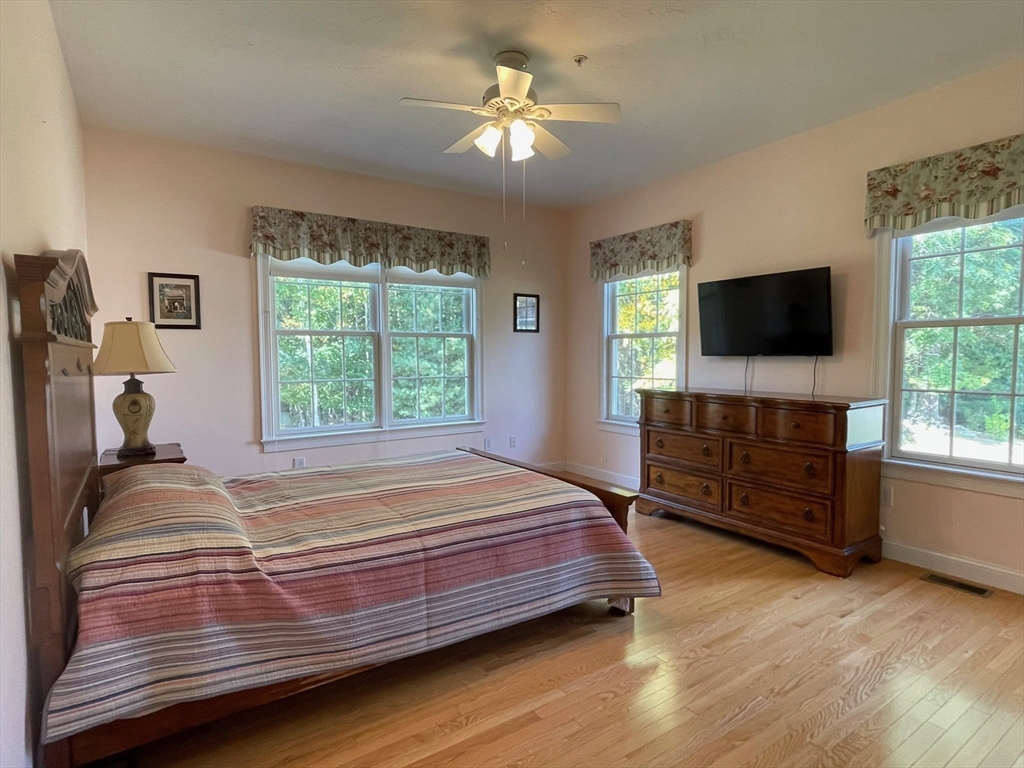 7 Sandstone Road Westford, MA 01886 - Photo 17 of 29 a bedroom with a bed and a flat tv screen on dresser