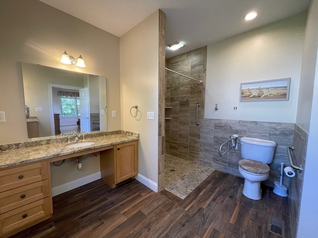 7 Sandstone Road Westford, MA 01886 - Photo 19 of 29 a bathroom with a granite countertop toilet a sink and a mirror