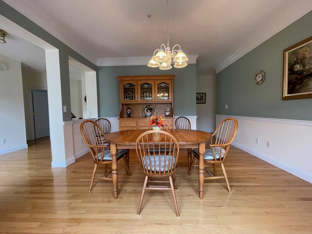 7 Sandstone Road Westford, MA 01886 - Photo 6 of 29 a dining room with furniture a chandelier and wooden floor