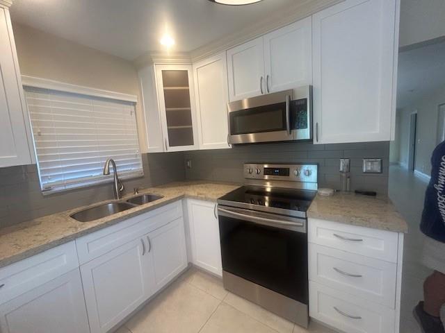 2821 Southeast 5th Circle Boynton Beach, FL 33435 - Photo 13 of 38 a kitchen with granite countertop a sink stainless steel appliances and cabinets