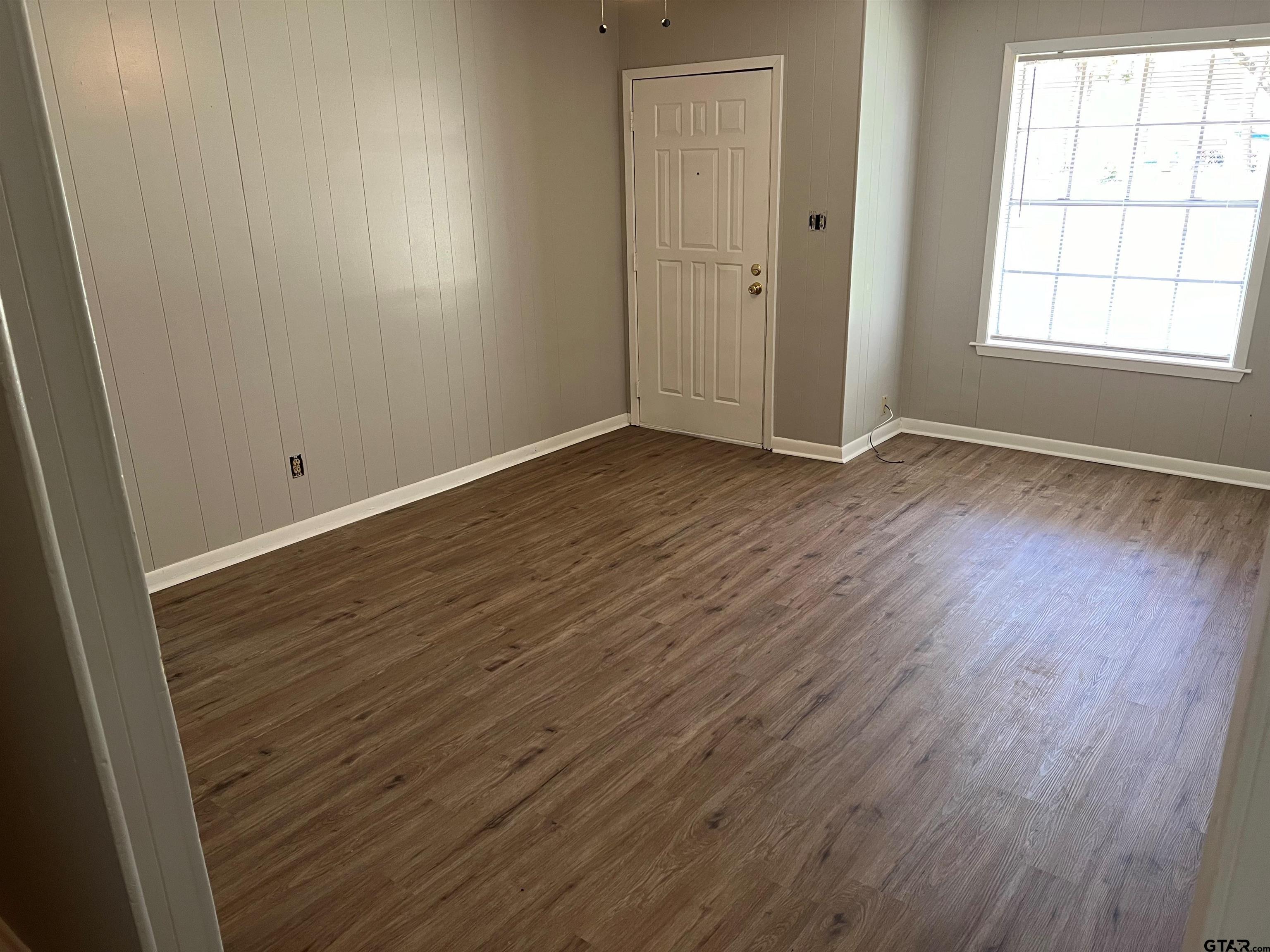3161 Glenda Avenue, Unit 202 Tyler, TX 75704 - Photo 4 of 13 an empty room with wooden floor and windows