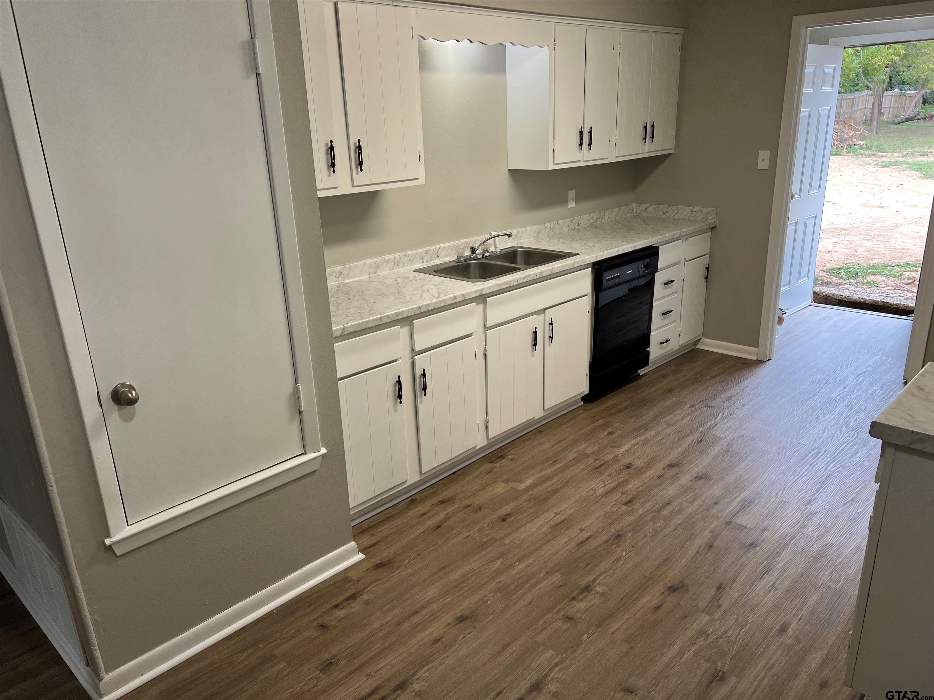3161 Glenda Avenue, Unit 202 Tyler, TX 75704 - Photo 5 of 13 a kitchen with cabinets appliances and a wooden floor