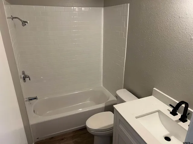 a white toilet sitting next to a bath tub