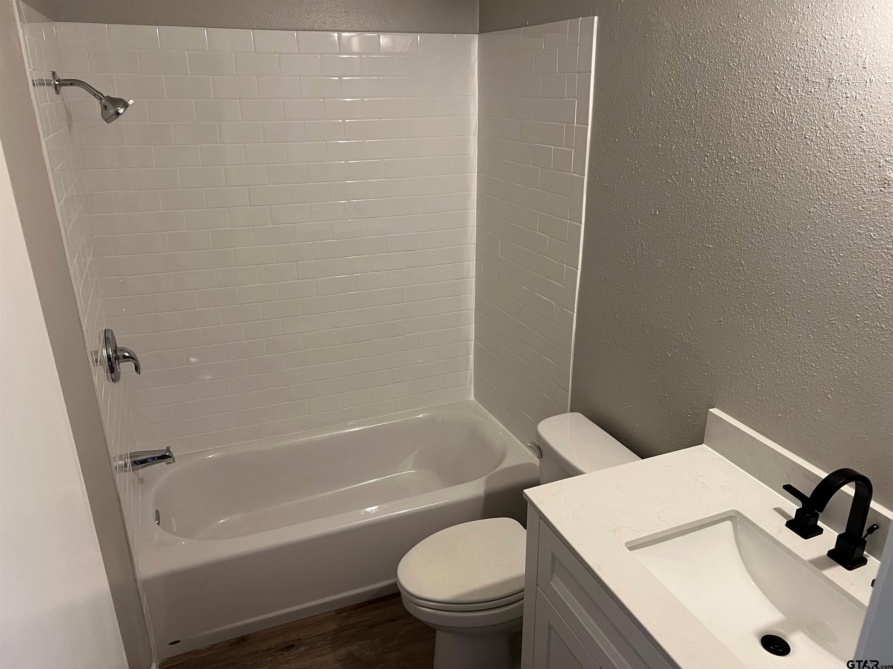 3161 Glenda Avenue, Unit 202 Tyler, TX 75704 - Photo 10 of 13 a white toilet sitting next to a bath tub