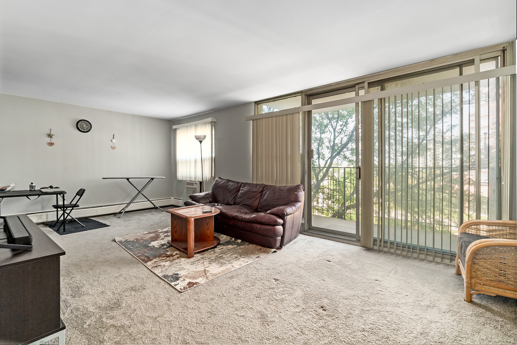 9001 Golf Road, Unit 4D Des Plaines, IL 60016 - Photo 5 of 15 a living room with furniture and large windows