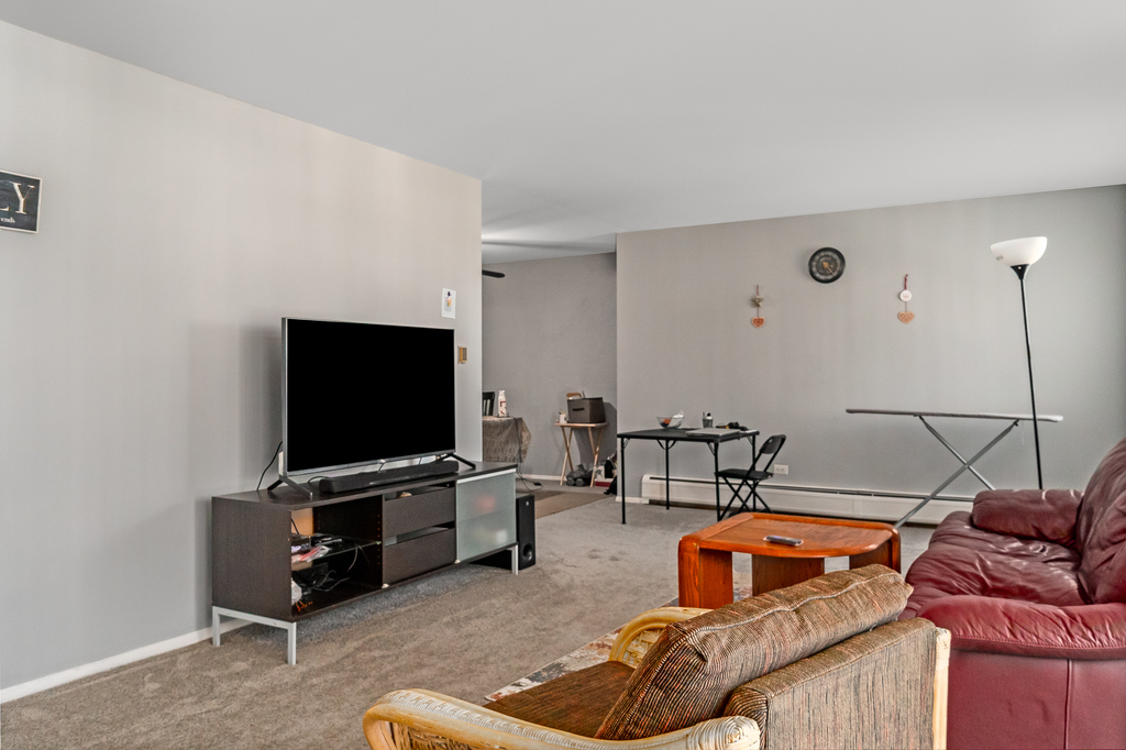 9001 Golf Road, Unit 4D Des Plaines, IL 60016 - Photo 6 of 15 a living room with furniture and a flat screen tv