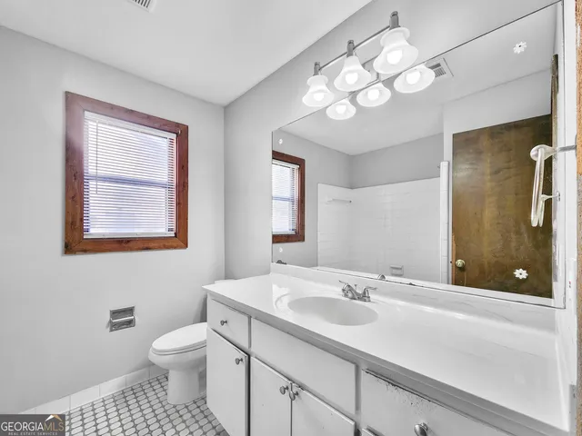 a bathroom with a sink a toilet and a mirror