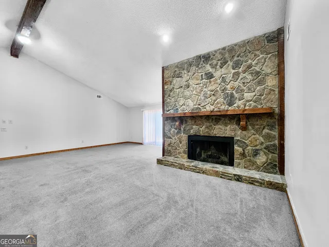 a view of empty room with a fireplace