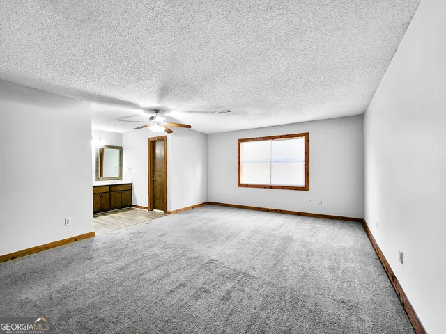 an empty room with windows and cabinet