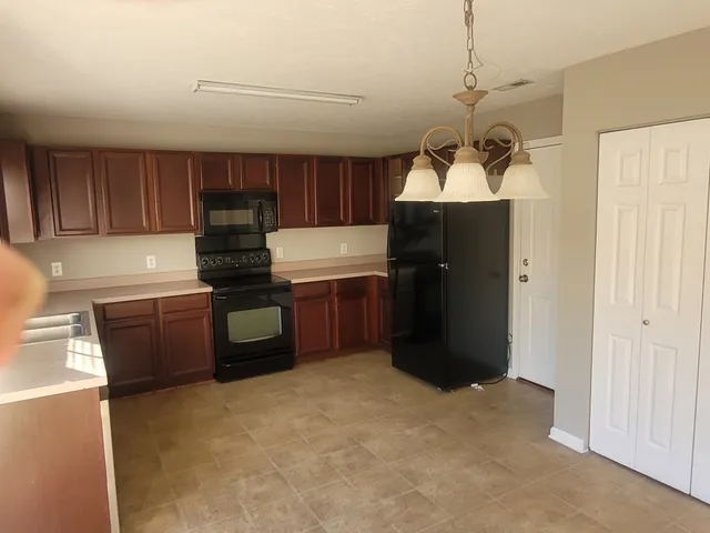 a kitchen with a refrigerator and a stove top oven