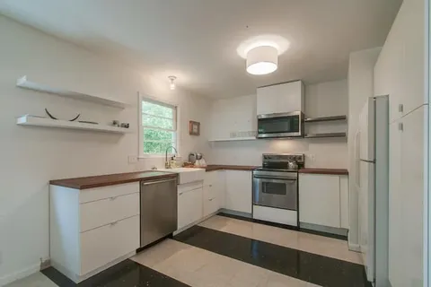 a view of a a dining room with furniture window and wooden floor