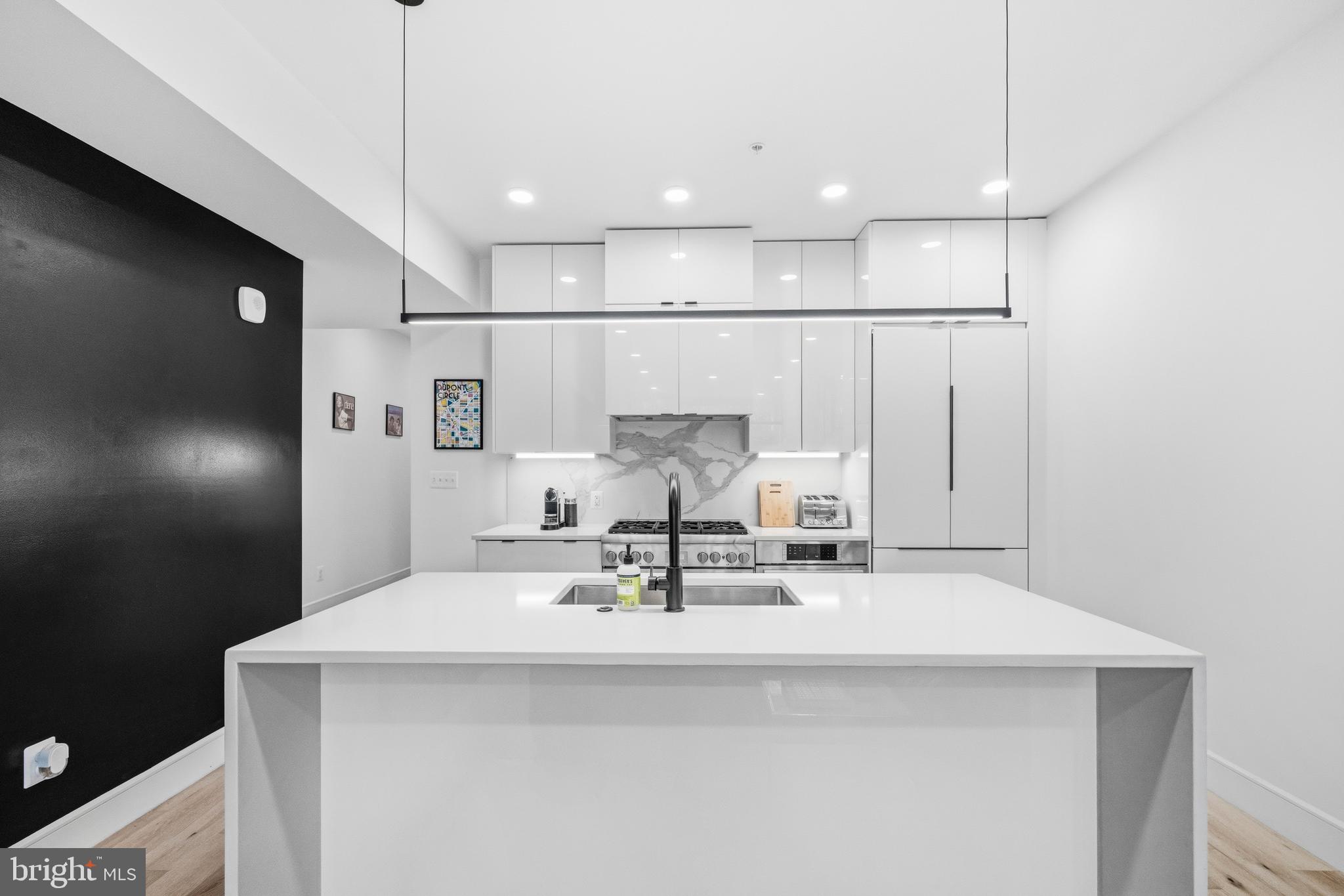 1729 T Street Northwest, Unit 3 Washington, DC 20009 - Photo 11 of 38 a kitchen with kitchen island white cabinets and stainless steel appliances