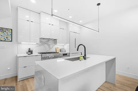 a large kitchen with kitchen island a large window in it