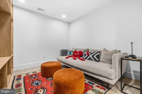 a living room with furniture a flat screen tv and a floor to ceiling window