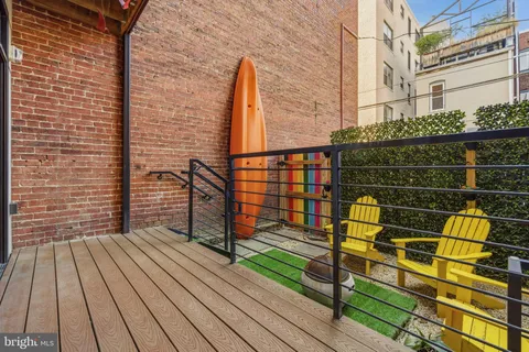 a view of a patio with table and chairs and wooden fence