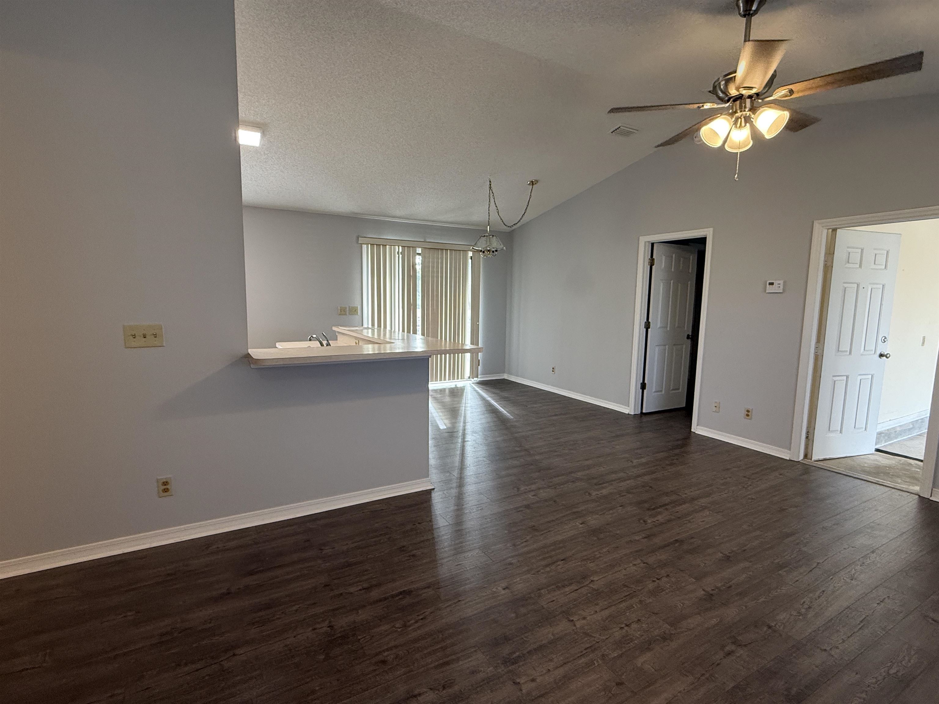 997 Irma Way St. Augustine, FL 32086 - Photo 2 of 10 an empty room with wooden floor and chandelier