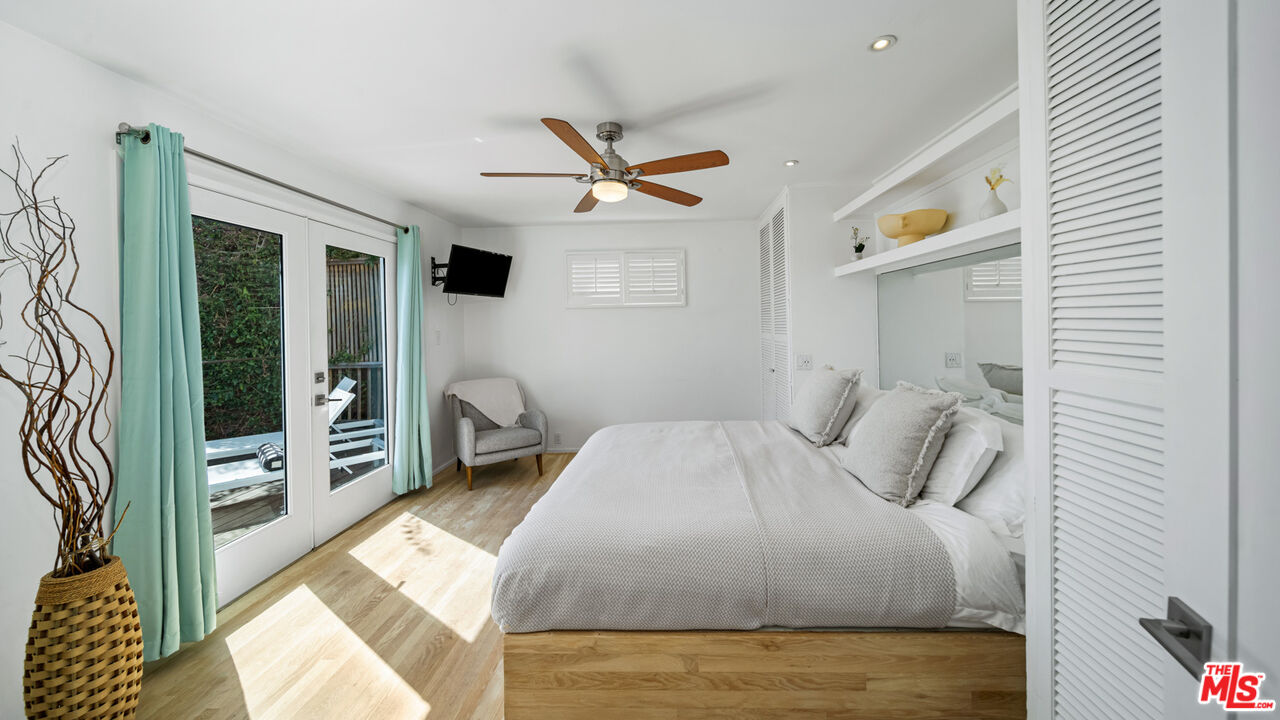 21344 Rambla Vista Malibu, CA 90265 - Photo 12 of 32 a bedroom with a bed a dresser and a floor to ceiling window