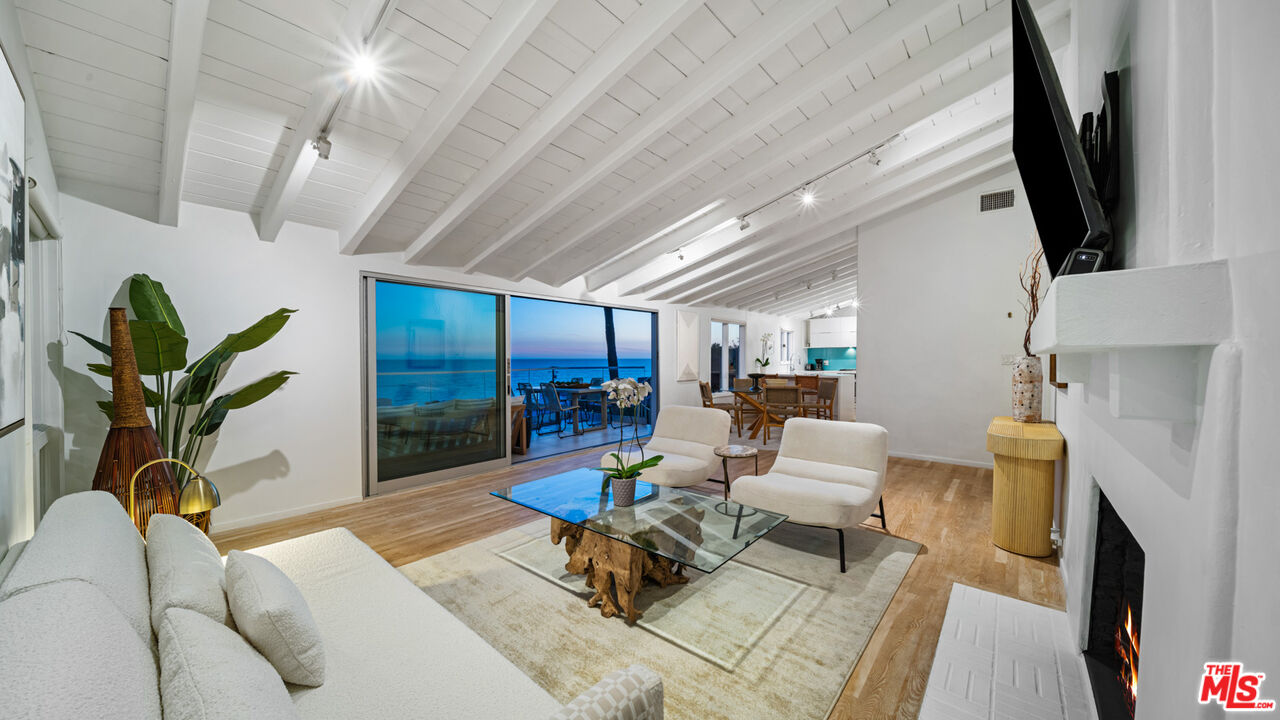 21344 Rambla Vista Malibu, CA 90265 - Photo 19 of 32 a living room with furniture a fireplace a potted plant and a table