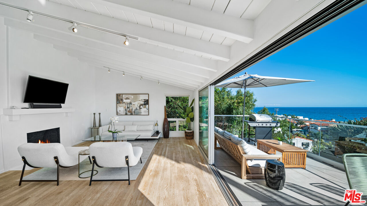 21344 Rambla Vista Malibu, CA 90265 - Photo 7 of 32 a living room with furniture a flat screen tv and a floor to ceiling window