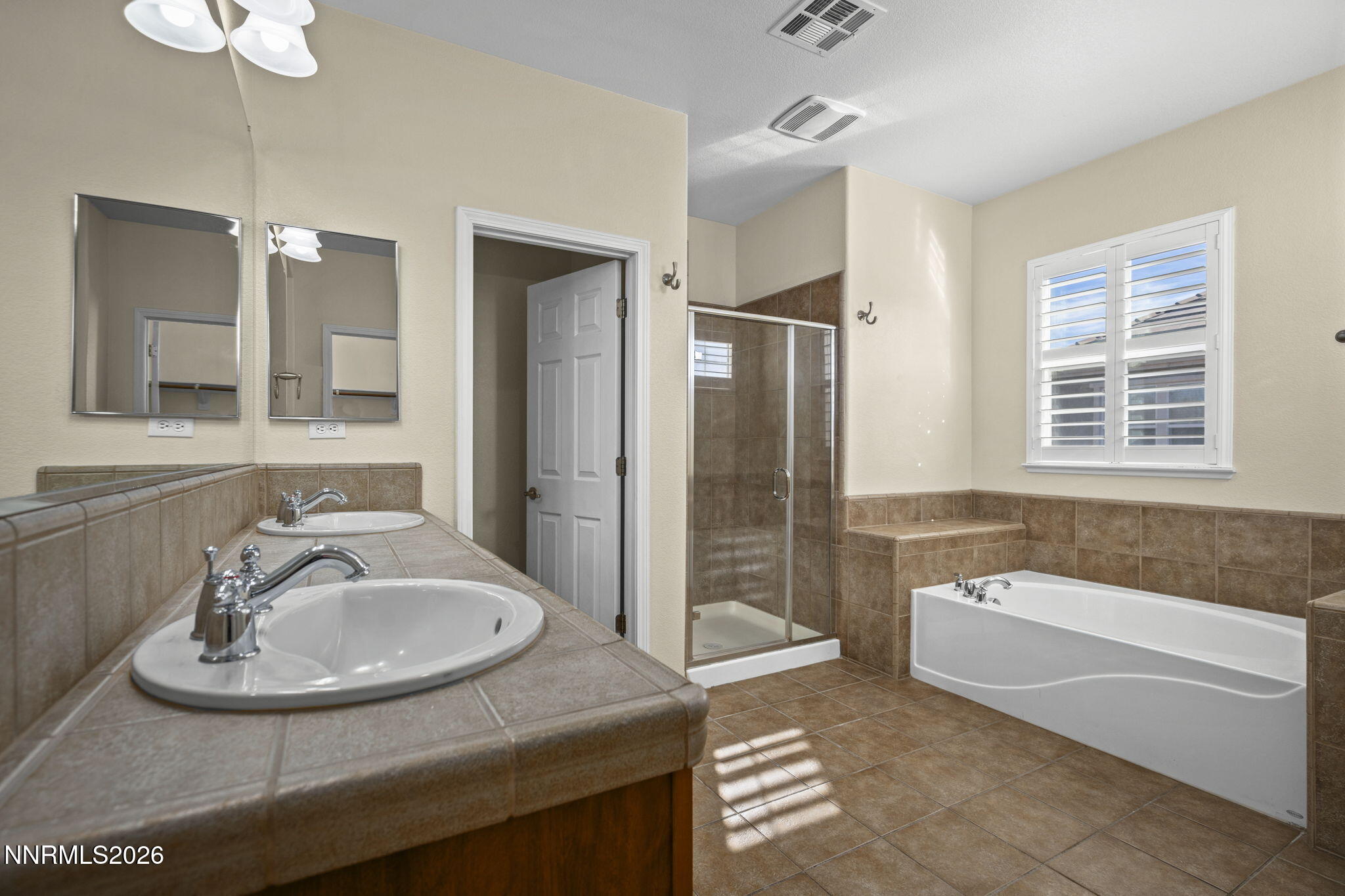 6953 Sacred Circle Sparks, NV 89436 - Photo 11 of 26 a bathroom with a sink double vanity granite tub shower and mirror