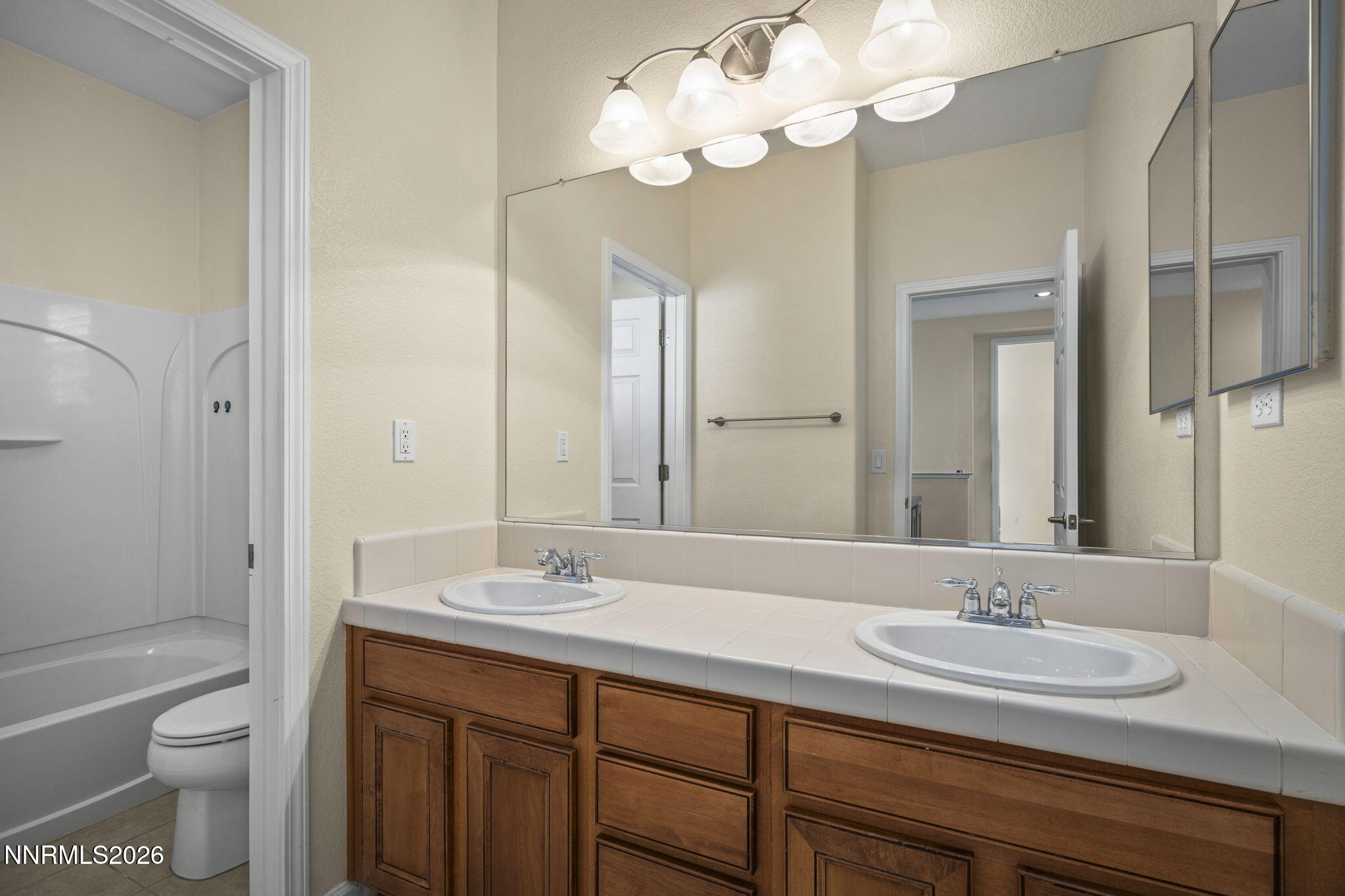 6953 Sacred Circle Sparks, NV 89436 - Photo 13 of 26 a bathroom with a sink a toilet and a mirror