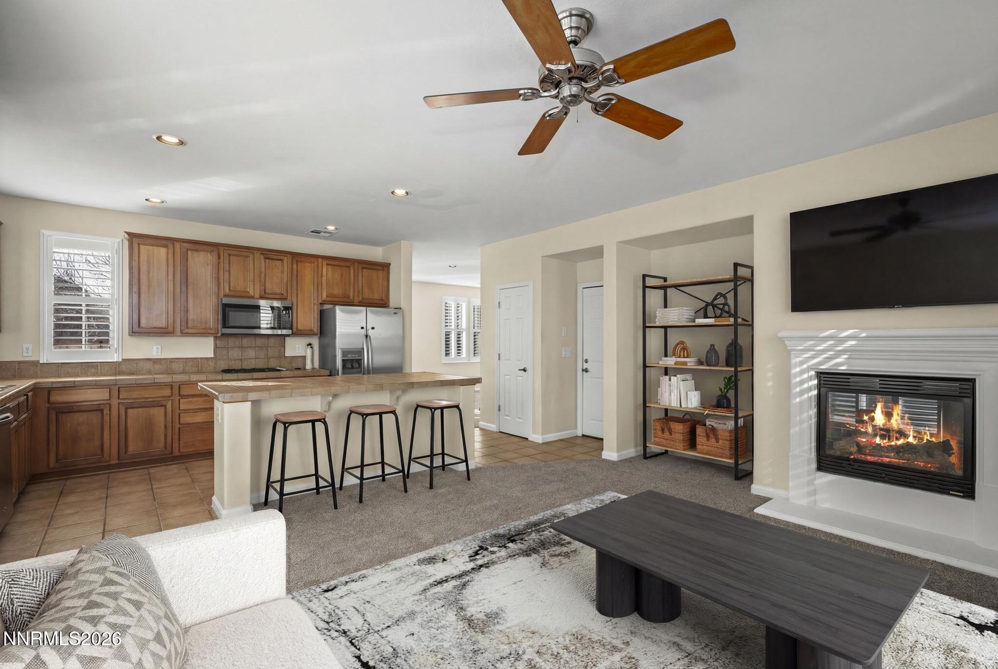 6953 Sacred Circle Sparks, NV 89436 - Photo 5 of 26 a living room with furniture a flat screen tv and a fireplace
