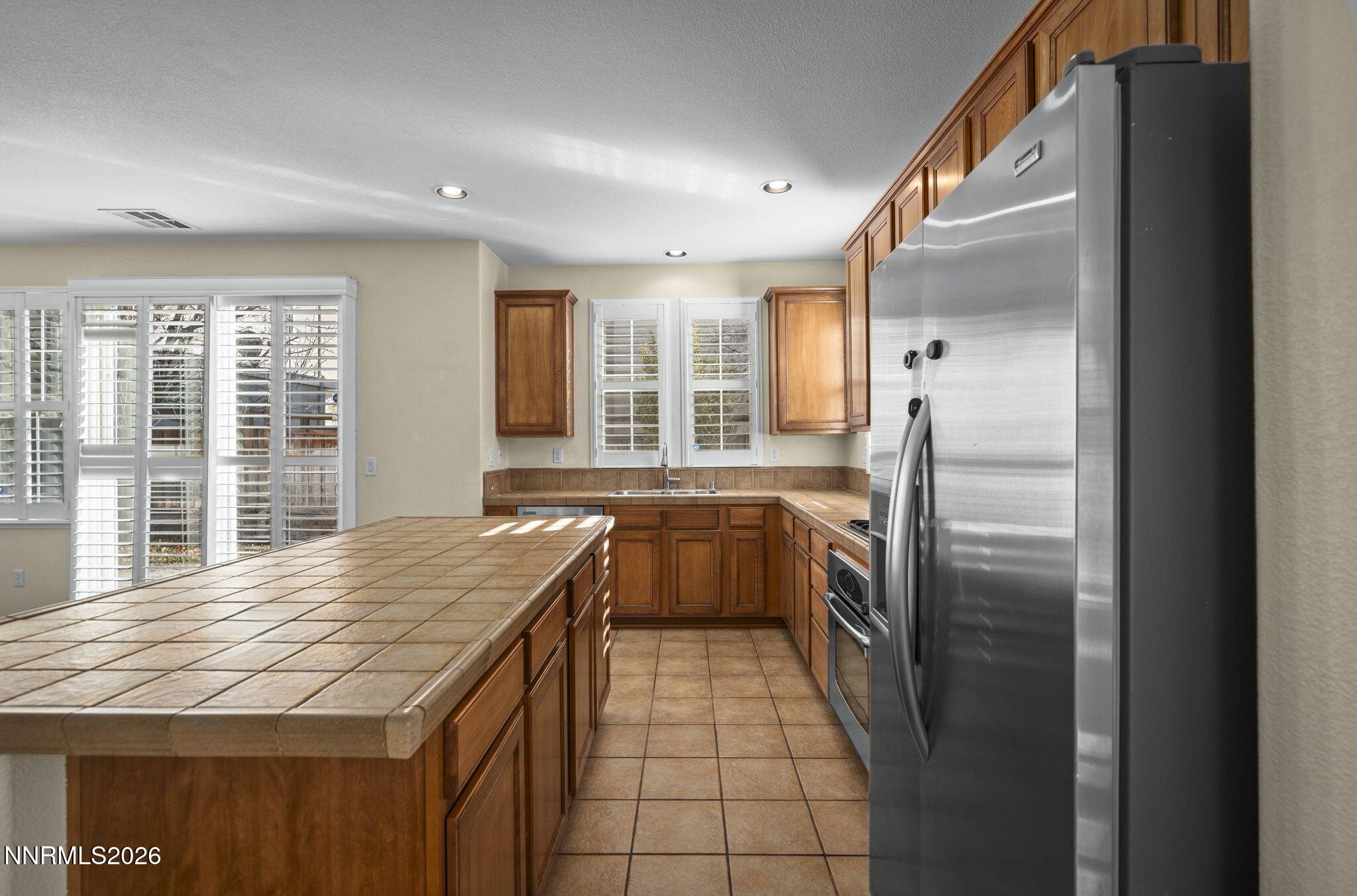 6953 Sacred Circle Sparks, NV 89436 - Photo 8 of 26 a kitchen with a refrigerator a sink and dishwasher