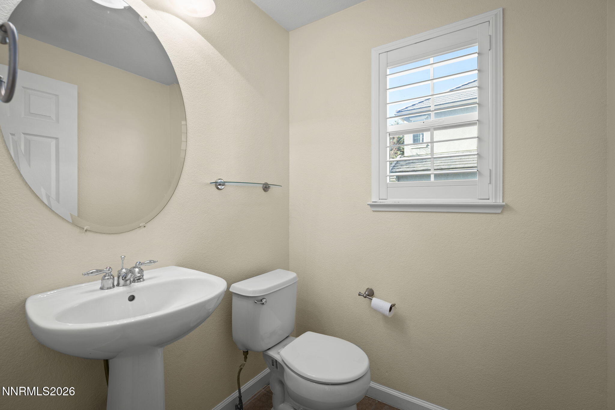 6953 Sacred Circle Sparks, NV 89436 - Photo 9 of 26 a bathroom with a sink a mirror and a toilet