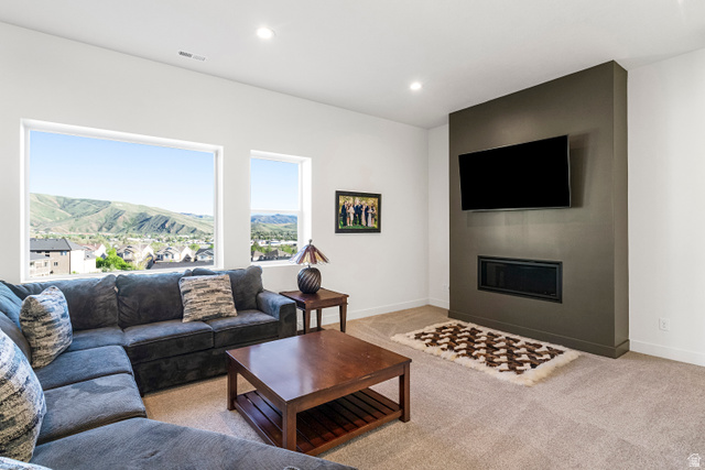 851 Grandview Drive Morgan, UT 84050 - Photo 38 of 68 Living area featuring large picture windows, recessed lighting, a modern fireplace, a wall-mounted flat-screen television, and neutral carpet flooring