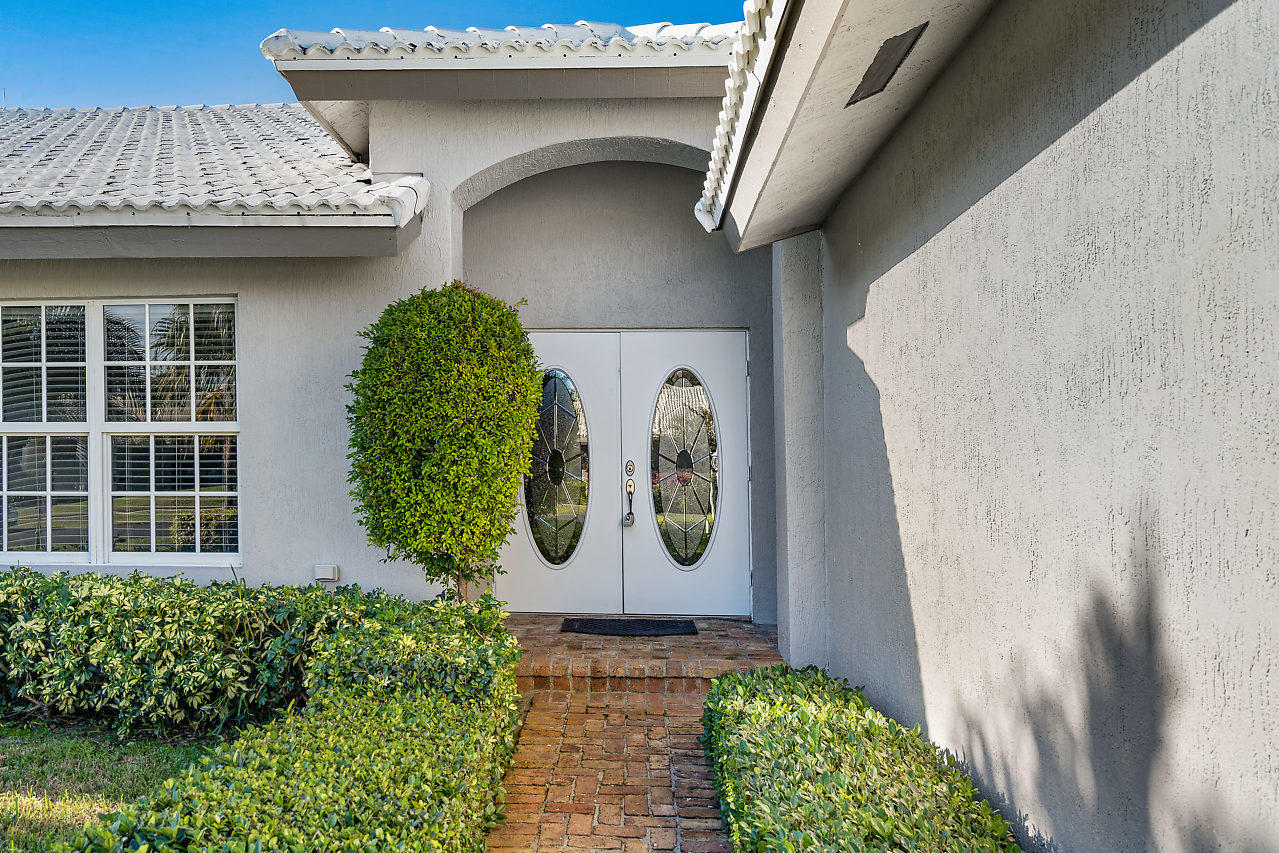 4572 White Cedar Lane Delray Beach, FL 33445 - Photo 2 of 37 a front view of a house with garden