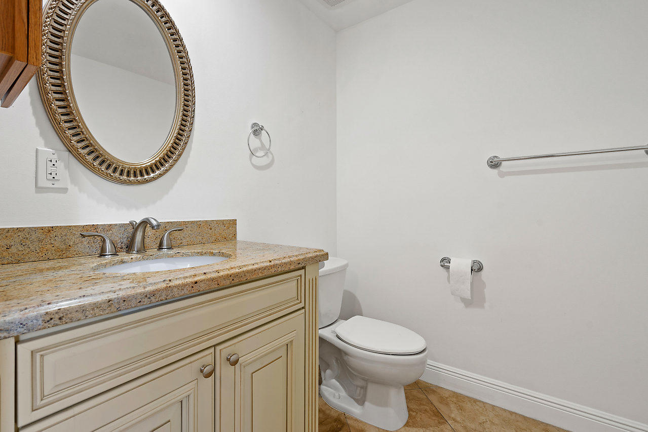 4572 White Cedar Lane Delray Beach, FL 33445 - Photo 14 of 37 a bathroom with a granite countertop toilet a sink and a mirror