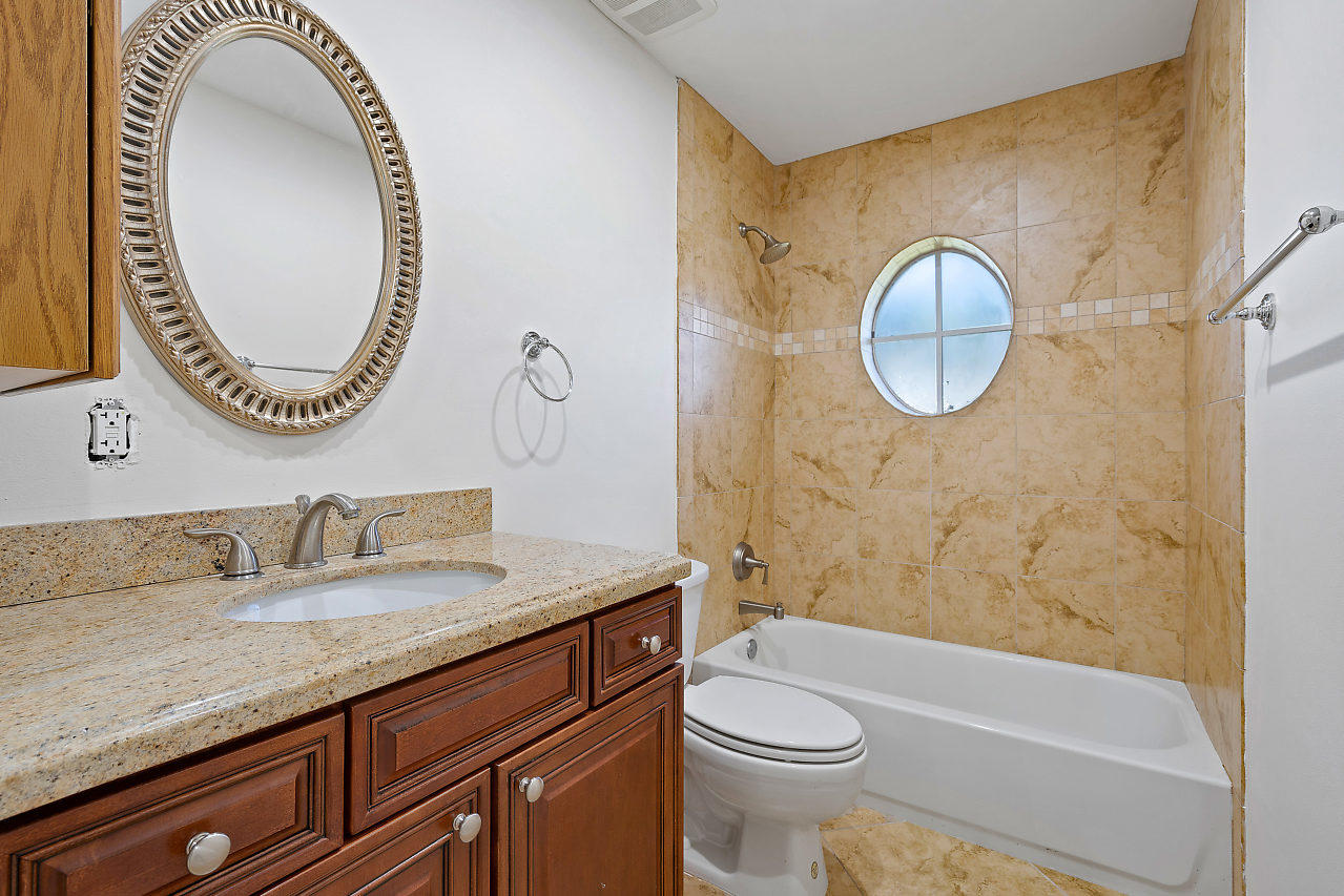 4572 White Cedar Lane Delray Beach, FL 33445 - Photo 28 of 37 a bathroom with a granite countertop sink mirror vanity and toilet