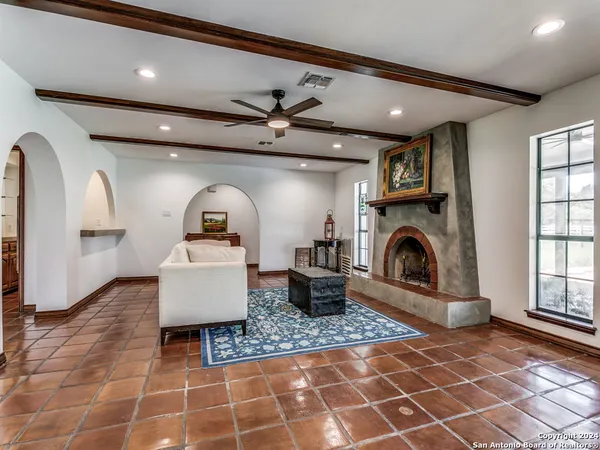 a living room with patio furniture and a fireplace