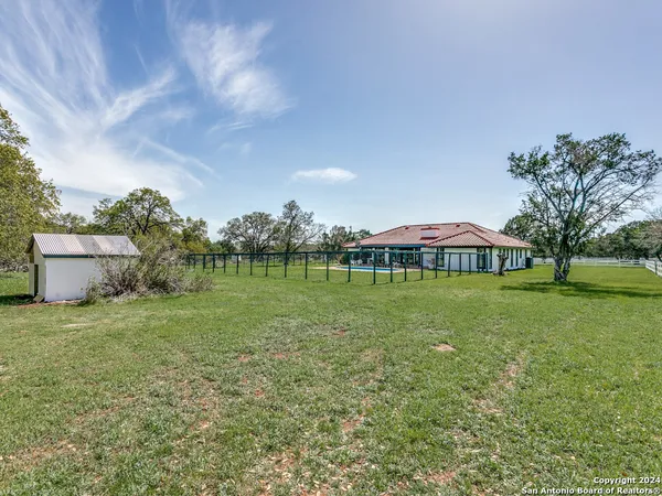 a view of a house with a yard and a large tree