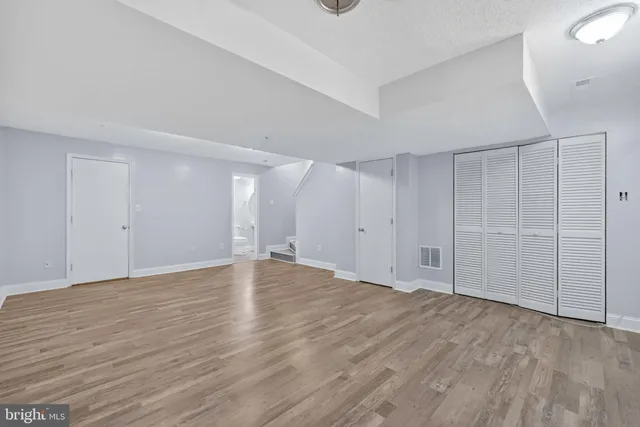 a view of an empty room with wooden floor