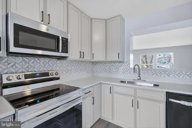 a kitchen with a sink stove and microwave