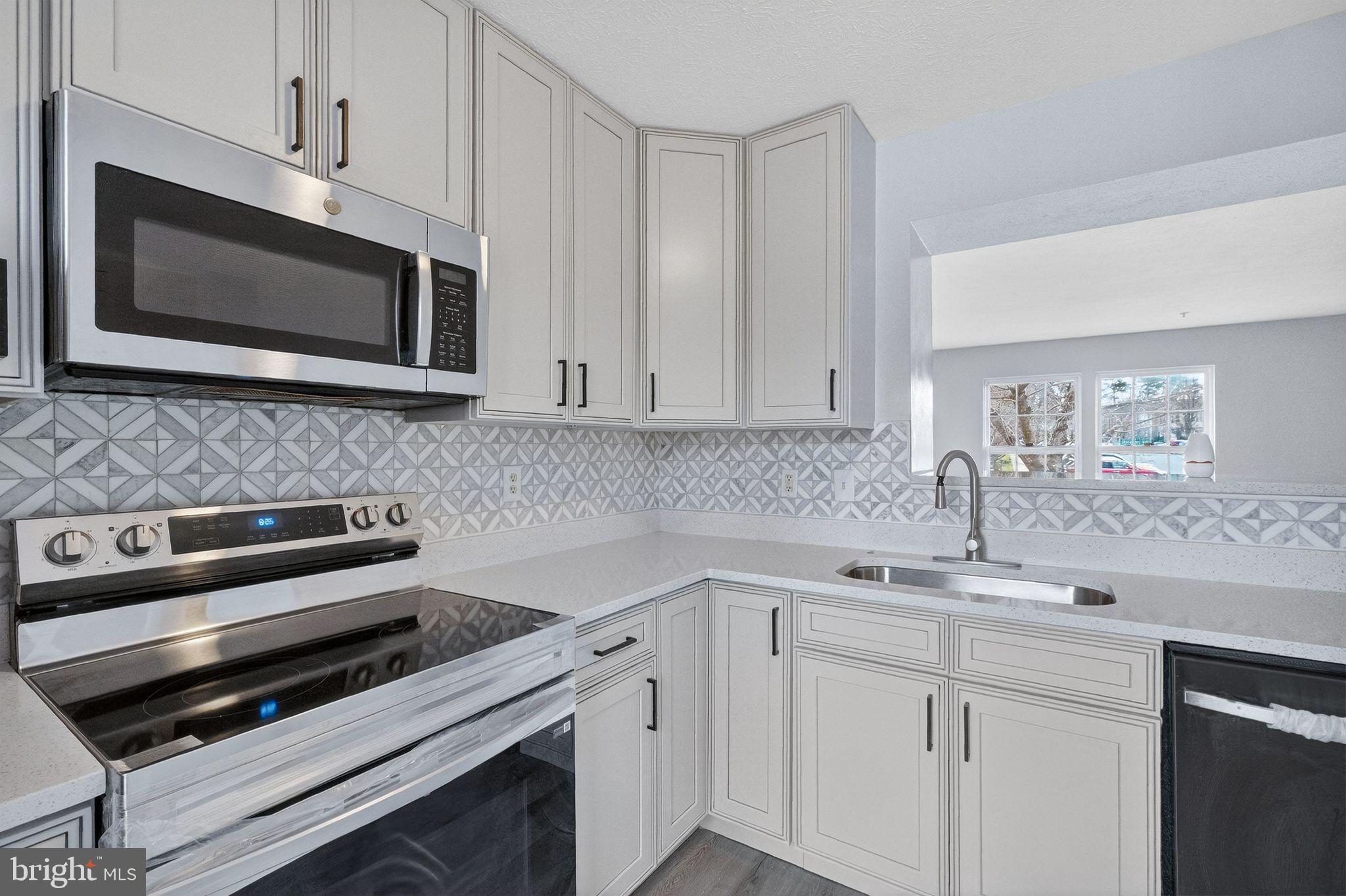 2116 Amber Way Baltimore, MD 21244 - Photo 3 of 22 a kitchen with a sink stove and microwave