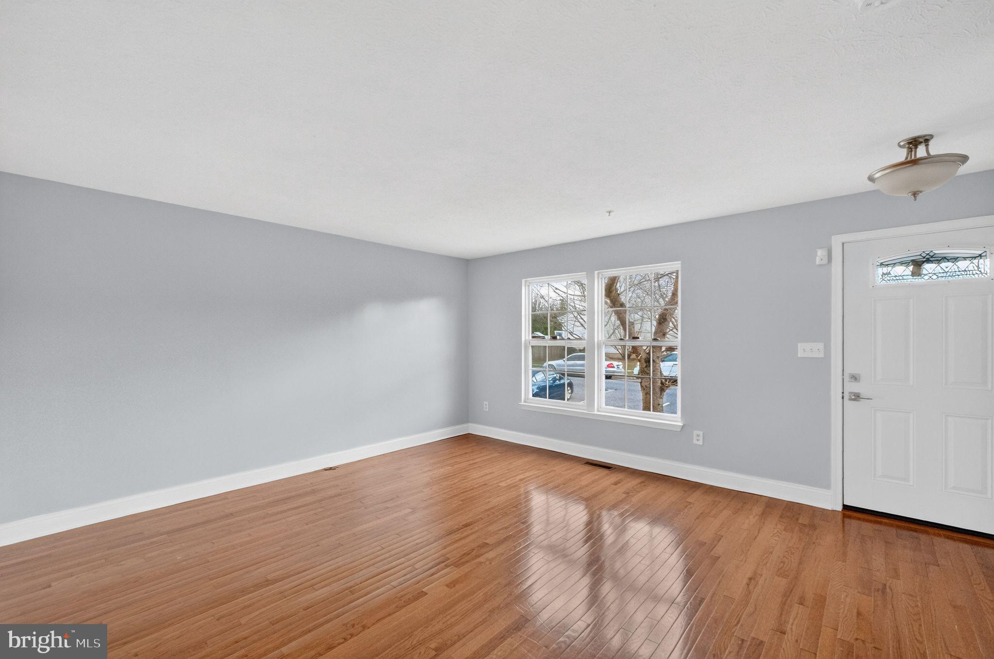 2116 Amber Way Baltimore, MD 21244 - Photo 4 of 22 an empty room with wooden floor and windows