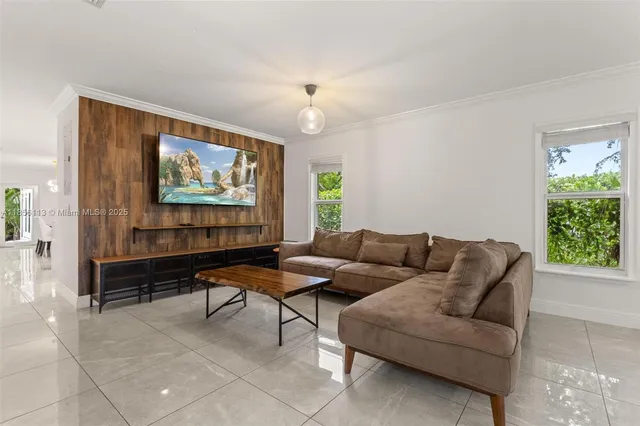 a living room with furniture a chandelier and a window