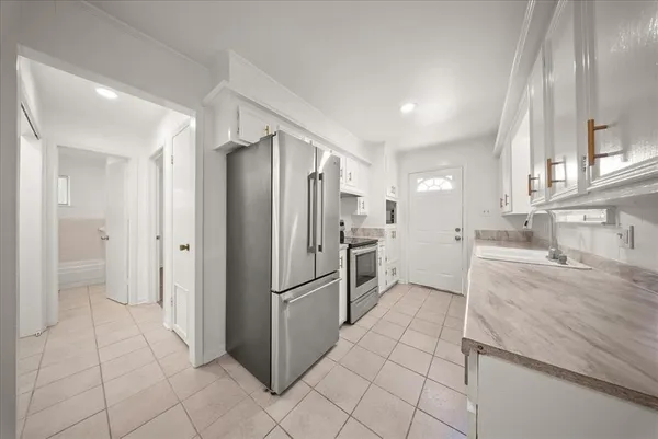 a kitchen with granite countertop a refrigerator and a sink