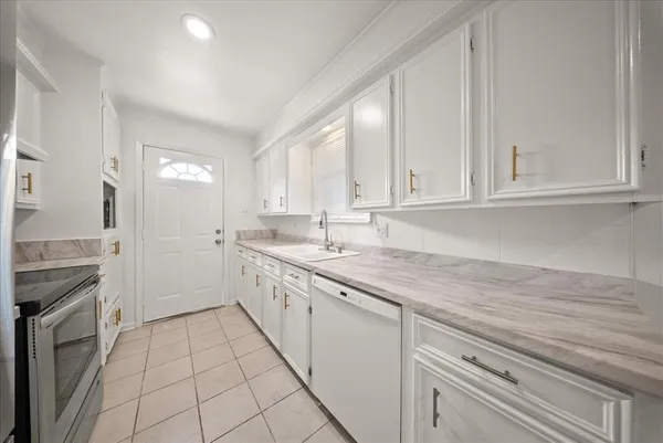a kitchen with granite countertop white cabinets and white appliances