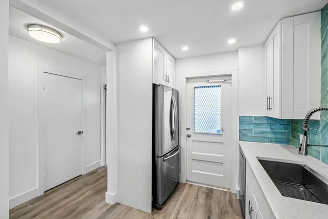 a kitchen with a refrigerator sink and cabinets