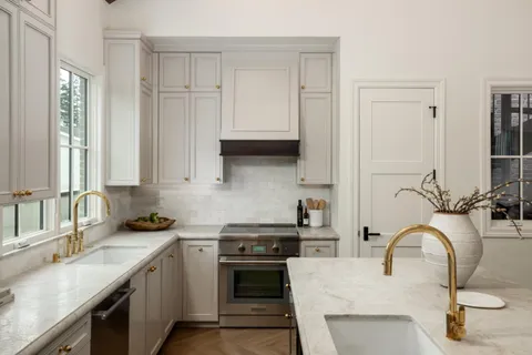 a kitchen with stainless steel appliances granite countertop a sink stove and cabinets