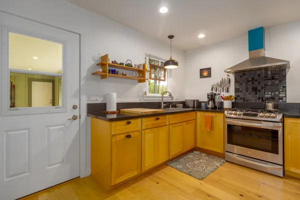 a kitchen with stainless steel appliances granite countertop a refrigerator a stove a sink and a microwave